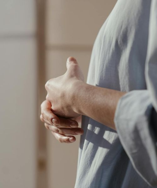 A close-up of a person's hands in a mindful gesture.
