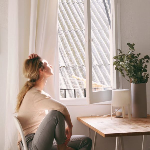 Person meditating in a bright room with iris-colored light.